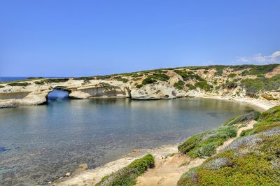 Scenic view of river against clear blue sky