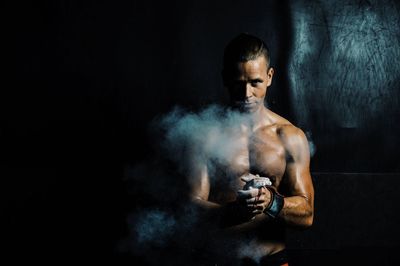 Portrait of muscular man dusting powder in gym