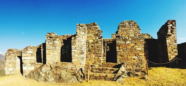 Old abandoned building against clear blue sky