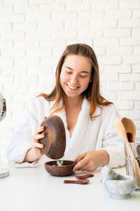 Young woman smiling while sitting on table