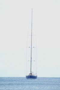 Sailboat sailing on sea against clear sky