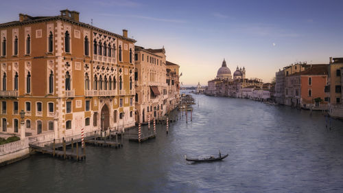 Boats in canal amidst buildings in city