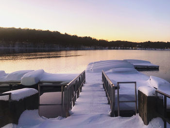 Scenic view of snow covered lake against sky during sunset