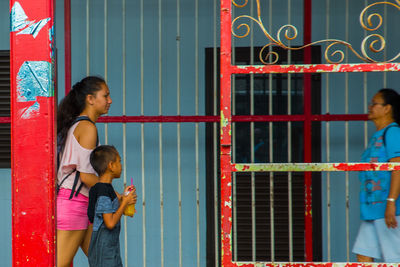 Rear view of a girl standing against wall