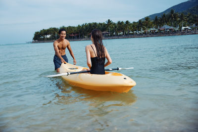 Rear view of woman kayaking in lake