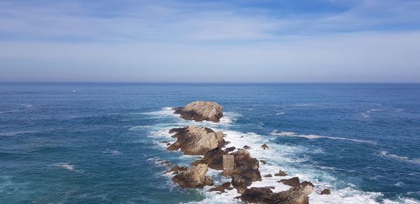 Rock formation in sea against sky