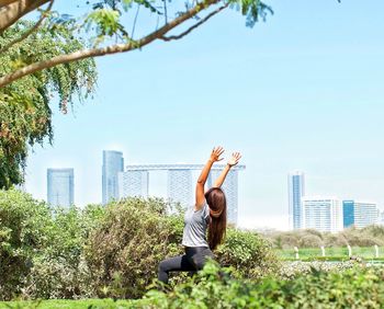 Man with arms raised against plants