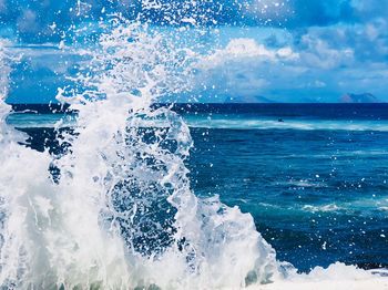 Waves splashing in sea against sky