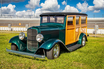 Vintage car on field against sky