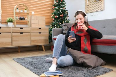 Portrait of young woman sitting on sofa at home