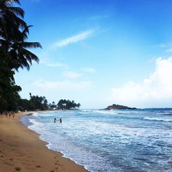 Scenic view of beach against blue sky