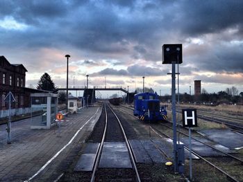 Railroad tracks against cloudy sky