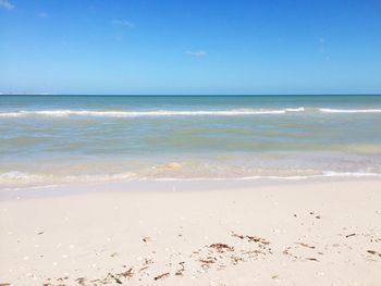 Scenic view of beach against clear blue sky