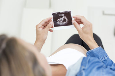 Close-up of pregnant woman lying on bed