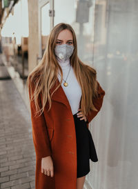 Portrait of beautiful woman wearing mask standing outdoors