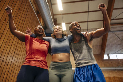 Excitement male and female athletes cheering together at sports court