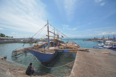 Sailboats moored in harbor