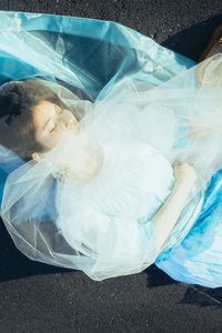 High angle view of woman lying down in plastic bag