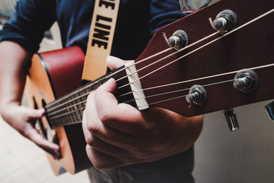 Midsection of man playing guitar