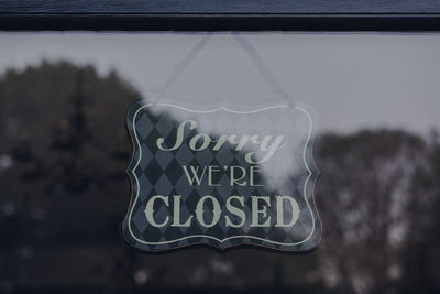 Close-up of text hanging on glass