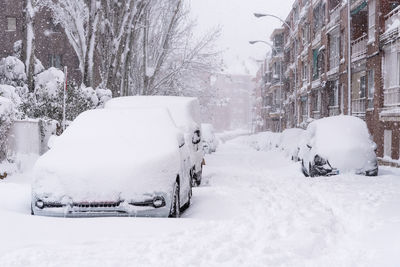 Snow covered street in city during winter
