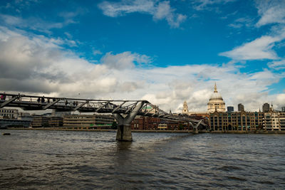 Bridge over river against cloudy sky