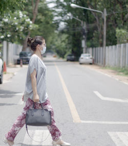 Rear view of woman walking on road in city