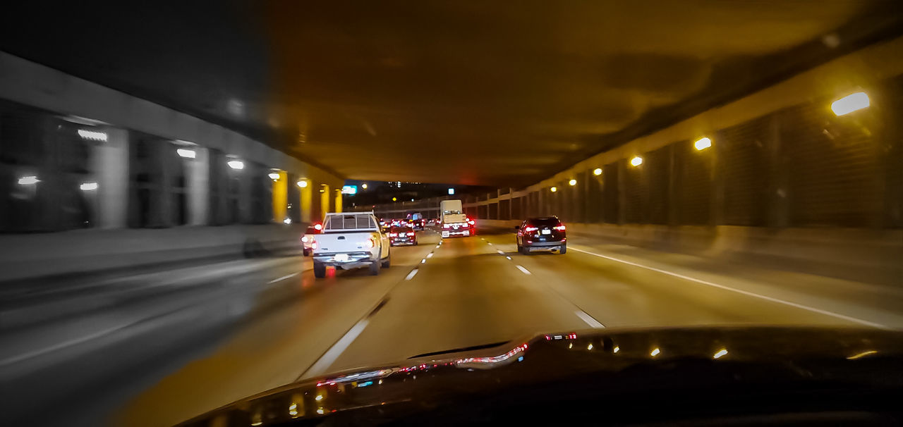 CARS ON ILLUMINATED ROAD IN CITY