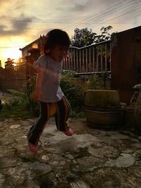 Full length of cute girl standing against sky during sunset