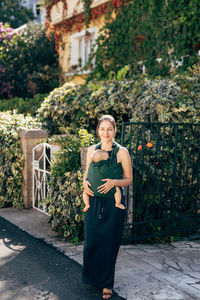 Portrait of woman standing against plants