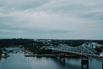 Bridge over river against cloudy sky