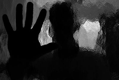 Close-up of silhouette hand against blurred background