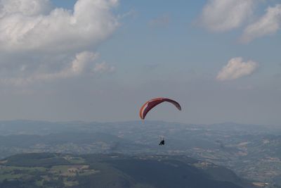 Low angle view of person paragliding against sky