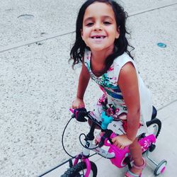 Portrait of smiling girl playing with bicycle