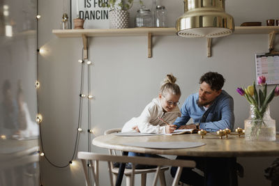 Father helping daughter doing homework
