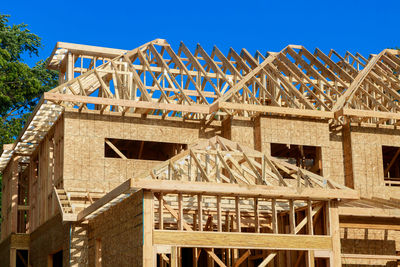 Low angle view of construction site against blue sky