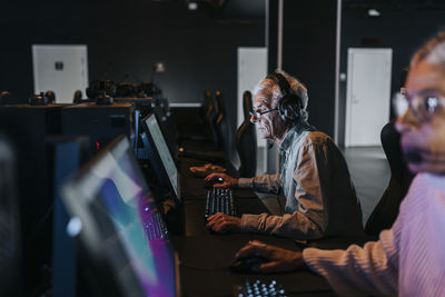 Female and male friends spending leisure time while playing video game at gaming center