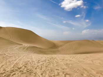 Sand dunes in desert against sky