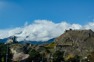 Low angle view of panoramic shot of mountains against blue sky