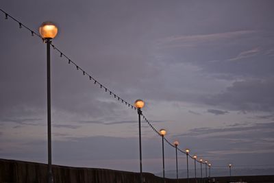 Low angle view of illuminated street light against sky