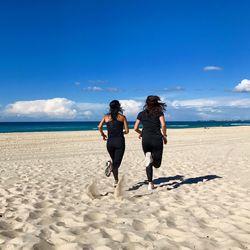 Rear view of women walking on beach