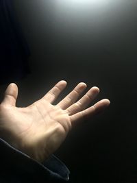 Close-up of human hand over black background