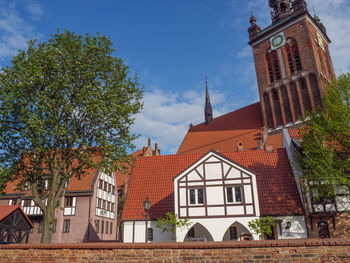 Low angle view of trees and buildings against sky