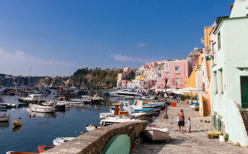 Boats moored at harbor by buildings in city