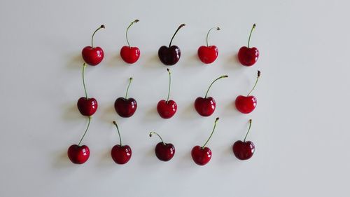 Close-up of red cherries against white background