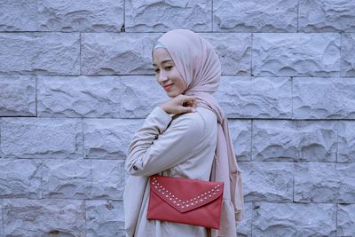 Low section of woman standing against wall