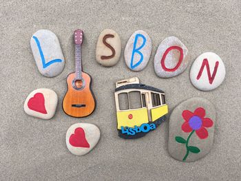 High angle view of toys and text on pebbles at beach