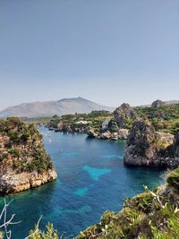 Scenic view of bay against clear blue sky