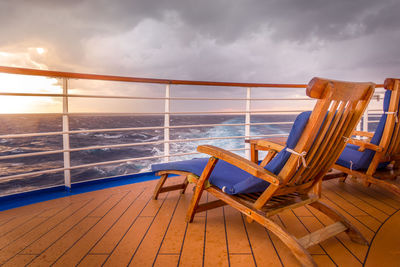 Close-up of railing against sea during sunset