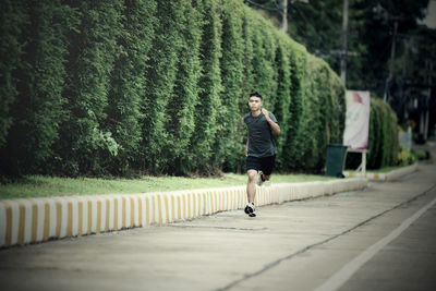 Full length of man running on footpath